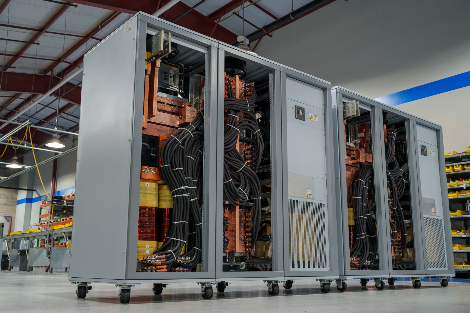 Angled view of two 250 kW, 6000 Adc MT Series power supplies with covers removed at Magna-Power's factory.