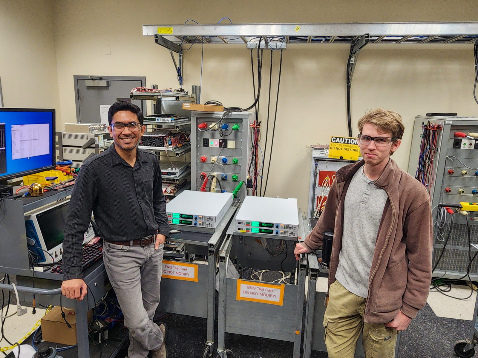 Parth Desai and Andrew Heater in Magna-Power's product validation lab performing long-term SLx Series master-slave testing.